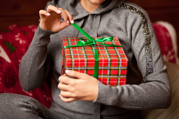 Femme avec boîte-cadeau de Noël dans une main.