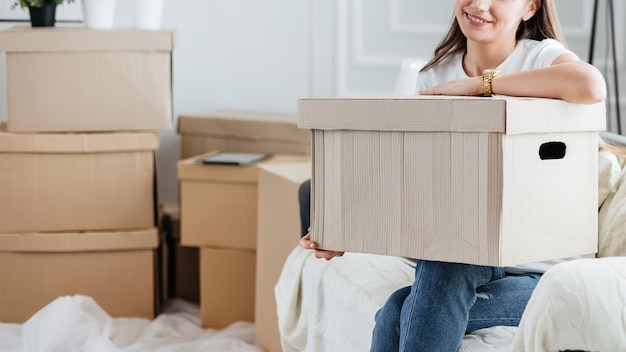 femme avec une boîte en carton assis sur le canapé