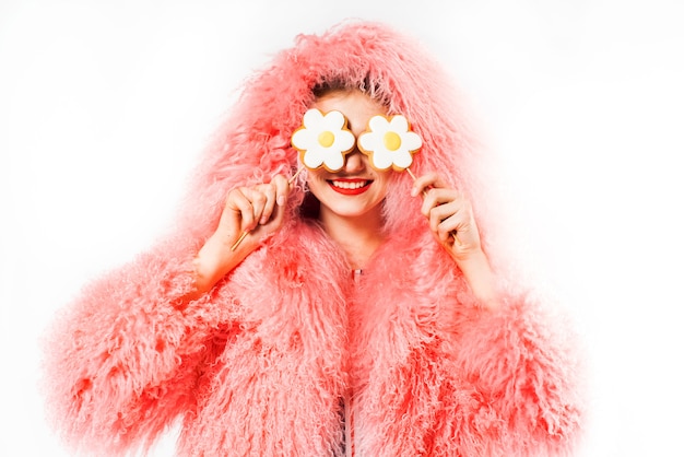 femme avec des bonbons sur blanc en manteau de fourrure rose.