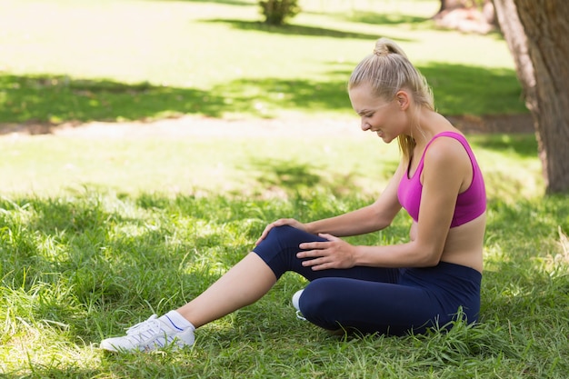 Photo femme en bonne santé et belle en sportswear assis dans le parc