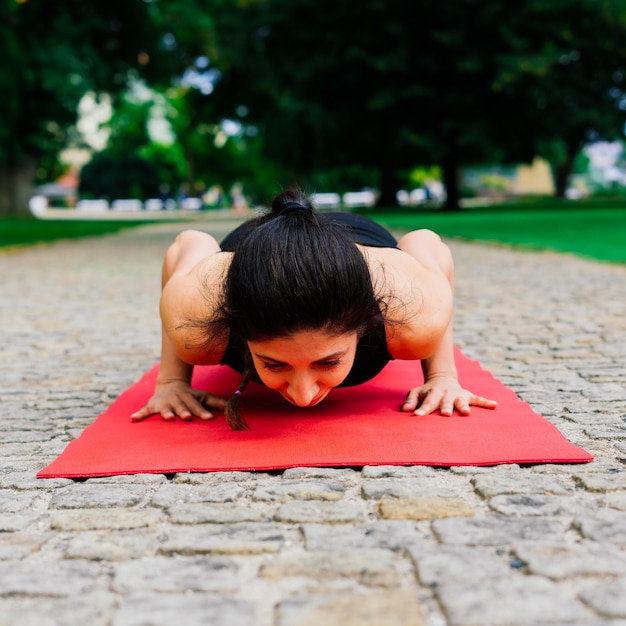 Femme en bonne santé dans un vêtement de sport pratiquant le yoga en plein air, faisant de l'exercice, portrait en pied.