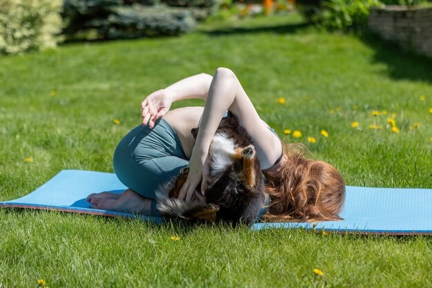 Une Femme En Bonne Santé Jouant Avec Un Chiot Assis Sur Un Tapis De Yoga