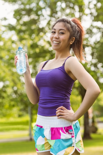 Femme en bonne santé tenant la bouteille d&#39;eau dans le parc