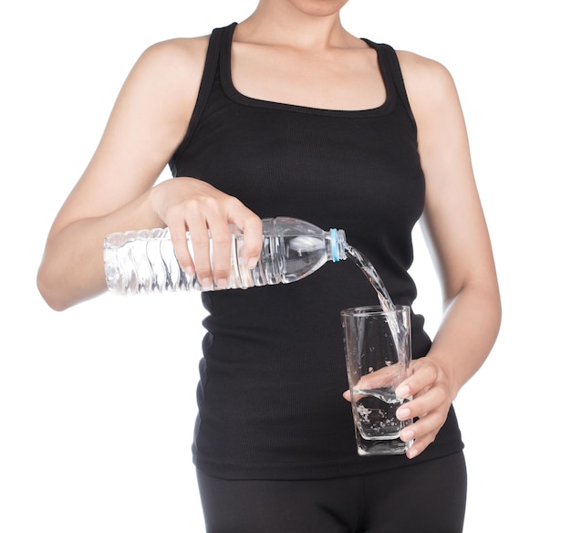 femme en bonne santé tenant une bouteille d'eau Verser de l'eau dans un verre isolé sur fond blanc.