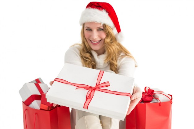 Femme en bonnet de Noel offrant un cadeau