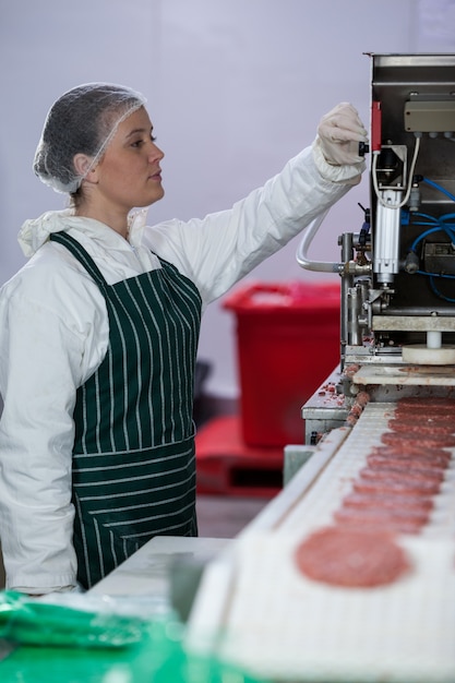 Femme boucherie transformant des fabricants de galettes de hamburger