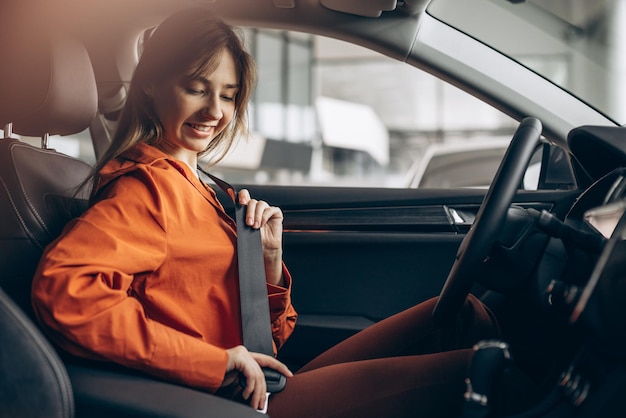 Femme boucle la ceinture de sécurité dans une voiture