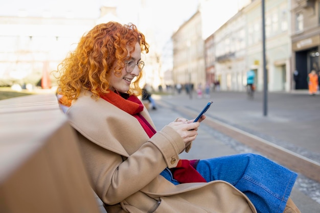 Femme bouclée à l'aide de son téléphone au centre de la ville