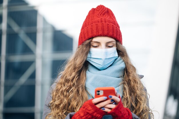 Femme bouclée debout sur la rue d'hiver.