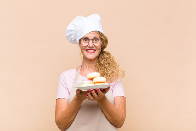 Femme de boulanger d'âge moyen aux longs cheveux bouclés isolé