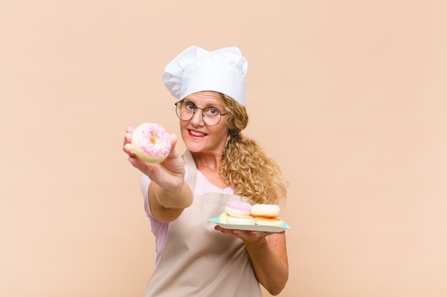 Femme boulangère d'âge moyen cuisson beignets