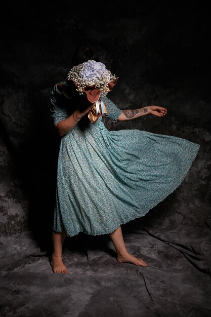 Photo une femme avec un bouquet debout contre le mur.