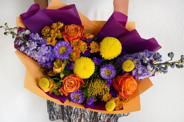 Femme avec bouquet de fleurs Belles fleurs pour les vacances Femme avec de belles fleurs dans ses mains à l'intérieur fond bouquet de fleurs pour fleuriste