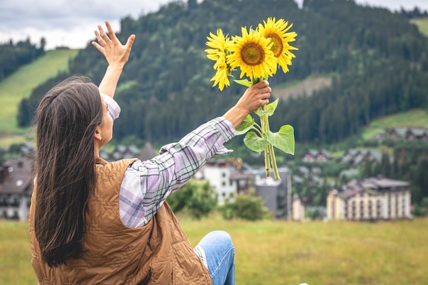 Femme Avec Un Bouquet De Tournesols Dans La Nature Dans Une Région Montagneuse