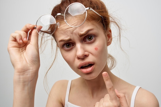 Femme avec un bouton sur le studio de cosmétologie du visage