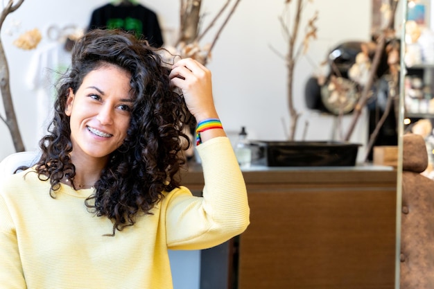 Femme avec un bracelet arc-en-ciel dans un salon de coiffure