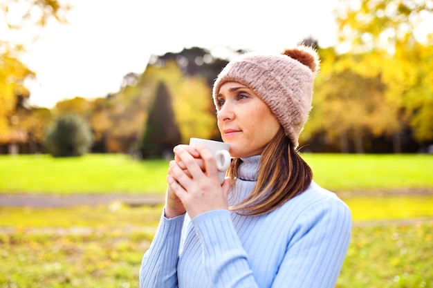 Femme à bras ouverts respirant de l'air frais et propre dans la brousse ou sur le terrain en automne ou en hiver