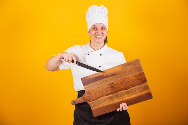 Femme brésilienne adulte chef maître en gastronomie tenant une planche à découper en bois et un couteau