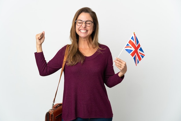 Femme brésilienne d'âge moyen tenant un drapeau du Royaume-Uni isolé sur un mur blanc faisant un geste fort