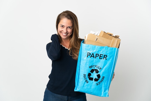Femme brésilienne d'âge moyen tenant un sac de recyclage plein de papier à recycler isolé