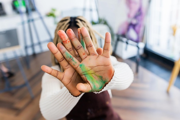 Femme brésilienne avec des dreadlocks en blouse blanche dans un studio d'art