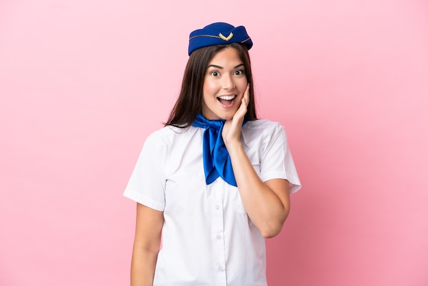 Femme brésilienne d'hôtesse d'avion isolée sur fond rose avec une expression faciale surprise et choquée