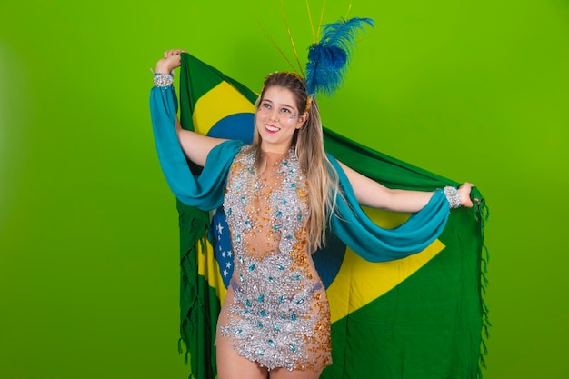 Femme brésilienne posant en costume de samba sur fond vert avec le drapeau du Brésil