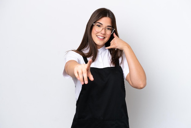 Femme brésilienne de serveur de restaurant isolée sur fond blanc faisant un geste de téléphone et pointant vers l'avant