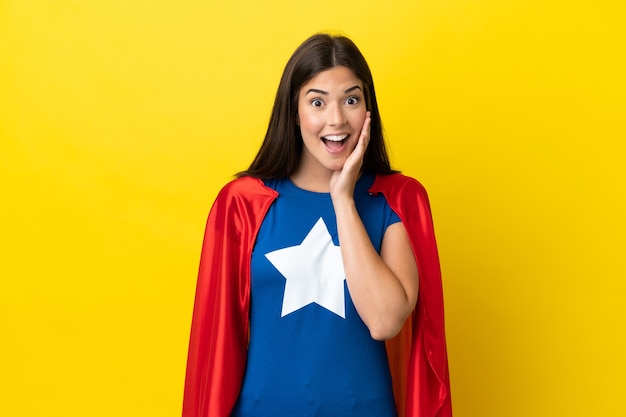 Femme brésilienne de super héros isolée sur fond jaune avec une expression faciale surprise et choquée