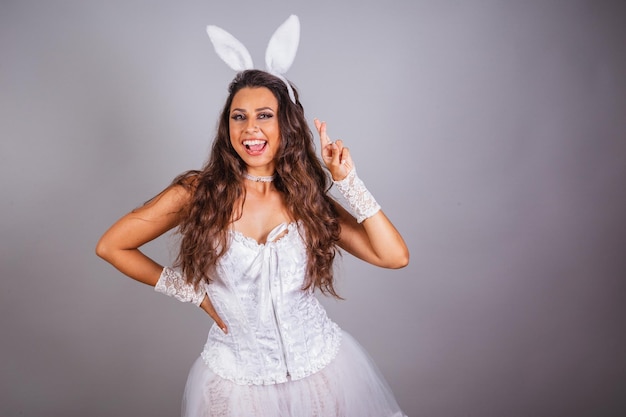 Femme brésilienne avec des vêtements de lapin croisés les doigts acclamant souhaitant