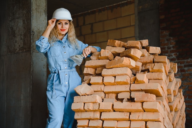 Femme avec brique dans le concept de construction