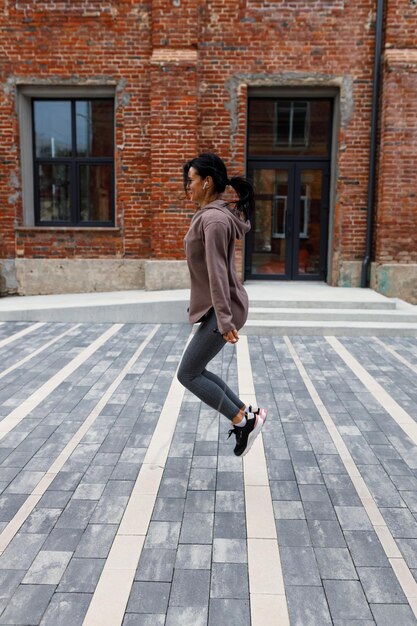 Femme brune faisant de l'exercice avec une corde à sauter à l'extérieur