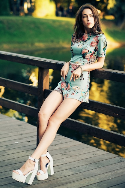 Femme brune Fashion posant sur le pont. Jour d'été.