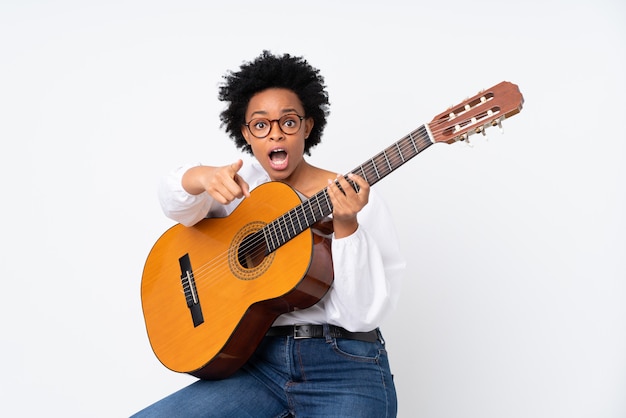 Femme brune avec une guitare sur fond blanc