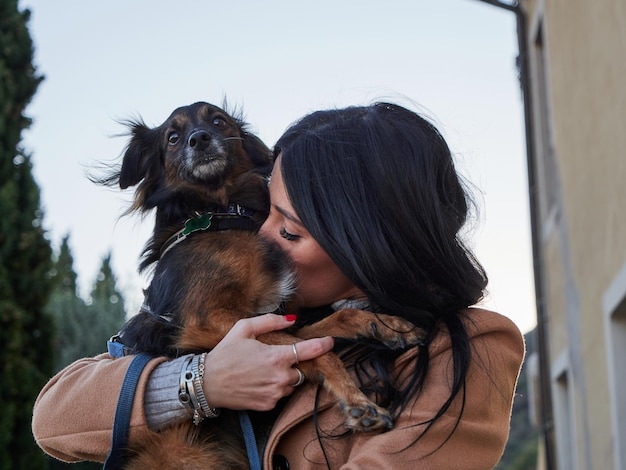 Photo femme brune joue avec un petit chien