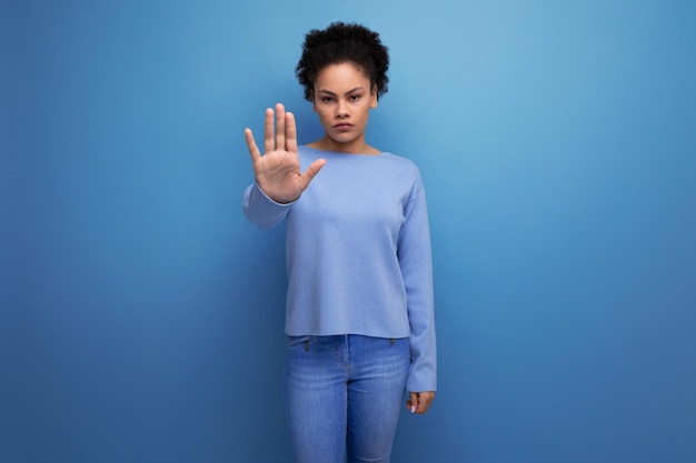 Femme brune latine aux cheveux ondulés avec geste de déni et de désaccord sur fond avec copie