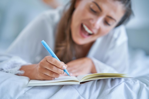 Femme brune sur mauvais avec bloc-notes ou livre