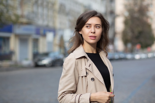 Une femme brune à la mode marche dans la rue