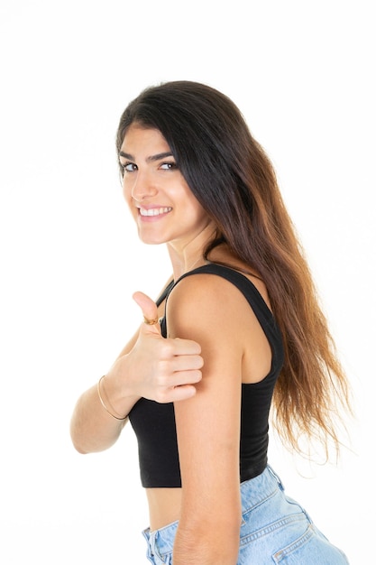 Femme brune pointant du doigt le pouce vers le haut à la recherche d'un sourire heureux