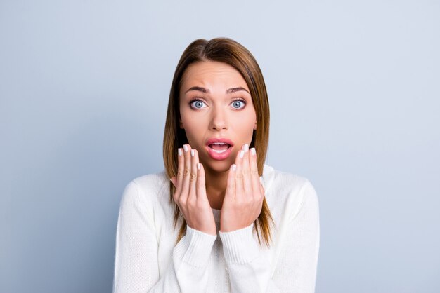 Femme brune posant contre le mur bleu clair