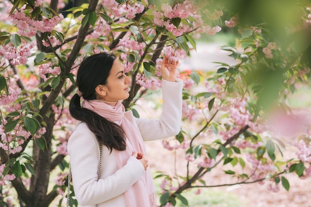 Femme brune profitant du printemps dans le parc