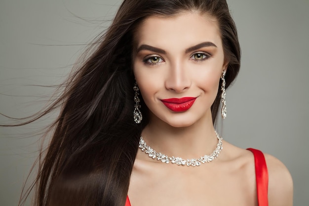 Femme brune souriante avec bijoux collier de diamants et boucles d'oreilles portrait de mode