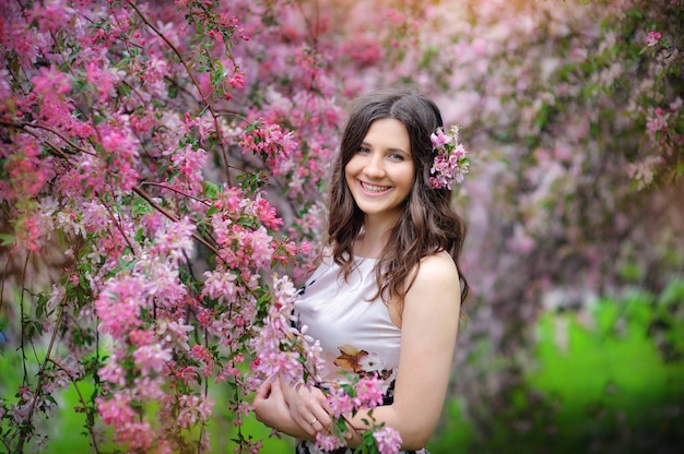 Femme brune souriante dans le parc par une chaude journée d'été