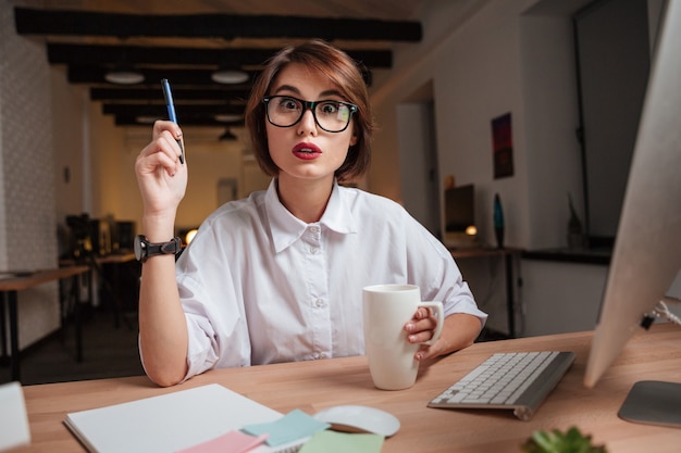 La femme de bureau a une idée. regarder la caméra