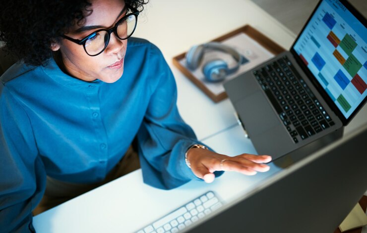 Photo femme avec bureau informatique et vérification de l'agenda et rappel pour l'administration agenda en ligne et écran d'ordinateur portable fille au bureau feuille de calcul de planification pour la gestion du temps par le haut