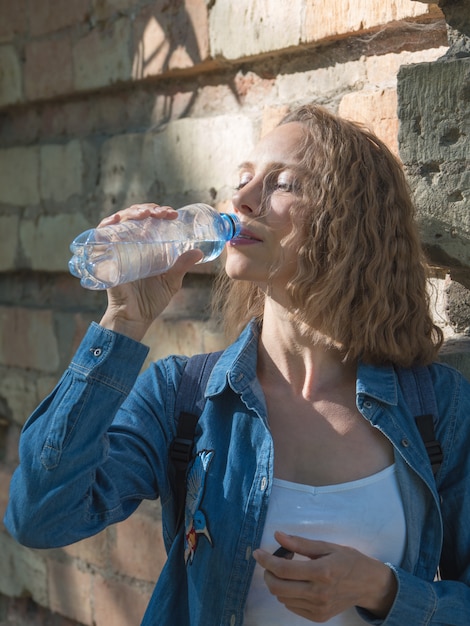 Femme buvant une bouteille d'eau sur une chaude journée d'été