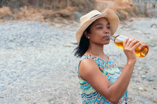 Femme buvant une bouteille de vin. Concept d'alcoolisme