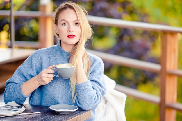 Femme buvant du café en automne parc