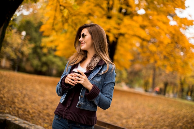 Femme buvant du café en automne parc