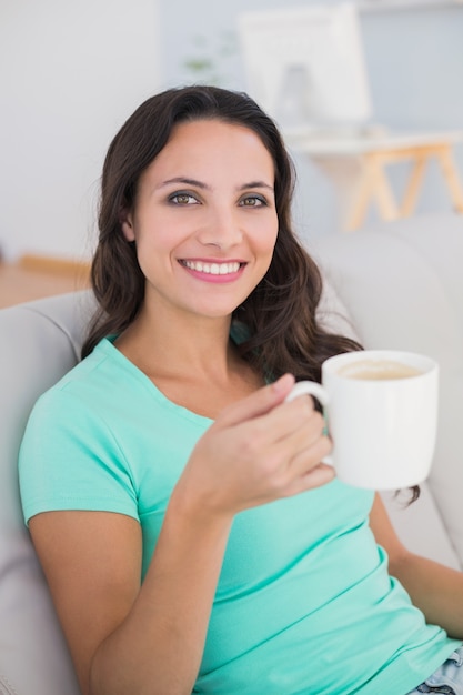 Femme buvant du café sur le canapé